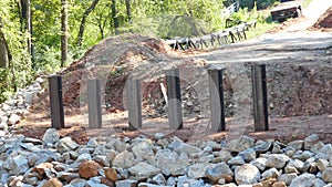 Steel pilings sit in front of rip rap on a bridge project