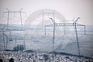 Steel pillar with high voltage electric power lines delivering electrical energy through cable wires on long distance