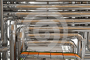 Steel pipelines and cables in factory interior as industrial zone background concept