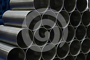 Steel pipes against industrial blurred background, close-up