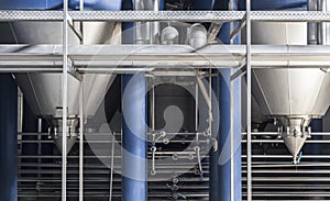 Steel pipes and filtration vats at brewery production beer factory, industrial background