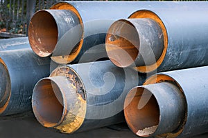 Steel pipes with thermal insulation in the shell of a plastic pipe at a construction site, closeup.