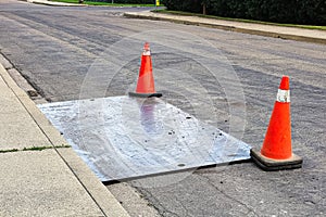 A steel plate on the road with construction pylons