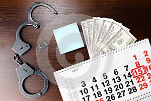 Steel police handcuffs, dollars money and April 15 on calendar,