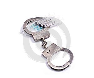 Steel police handcuffs and syringes for