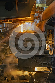 Steel production in electric furnaces. Sparks of molten steel. Electric arc furnace shop .