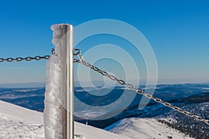 Steel railing tube with a chain, top of path to snezka from pink mountain, krkonose mountain, winter morning