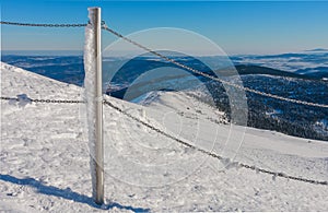 Steel railing tube with a chain, top of path to snezka from pink mountain, krkonose mountain, winter morning