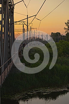 Steel railway bridge on sunset