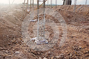 Steel-reinforced concrete columns on the ground for the next stage of work on the construction site.