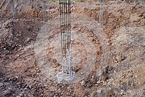 Steel-reinforced concrete columns on the ground for the next stage of work on the construction site.