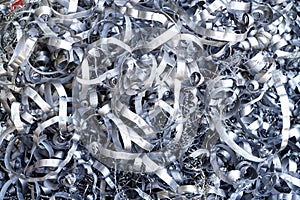 Steel scrap materials recycling. Aluminum chip waste after machining metal parts on a cnc lathe. Closeup twisted spiral steel