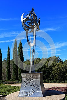 Respect Unity Peace steel sculpture in park by blue sky