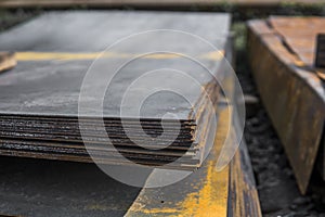 Steel sheets deposited in stacks in packs at the warehouse of metal products. Weathered metals sheet for construction