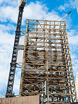 Steel skeleton tall building under construction with Crane tower.