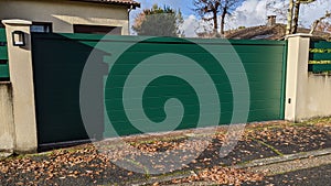 Steel sliding large green metal gate fence on modern house street