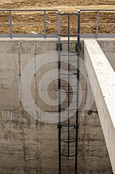The steel stair on the concrete wall of the well