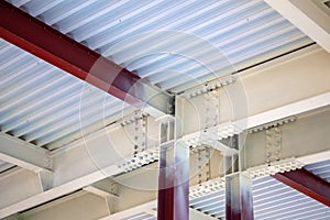 Steel structure of  building with steel beams,  variety of joints and fasteners is partially covered with fire retardant