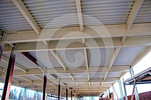 Steel structure of  building with steel beams,  variety of joints and fasteners is partially covered with fire retardant