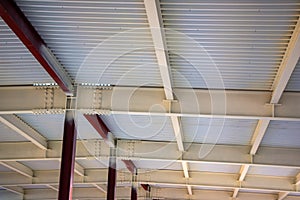 Steel structure of  building with steel beams,  variety of joints and fasteners is partially covered with fire retardant