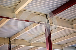 Steel structure of  building with steel beams,  variety of joints and fasteners is partially covered with fire retardant