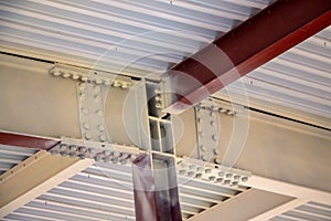 Steel structure of  building with steel beams,  variety of joints and fasteners is partially covered with fire retardant