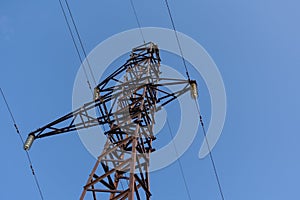 Steel structure of a power line support against a clear blue sky. Communication tower for power supply unit