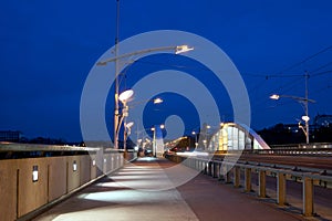 The steel structure of the road bridge over the Warta River during the night in the city of Poznan