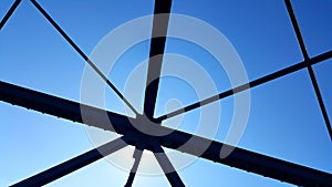 Steel structure support above the bridge on blue sky background