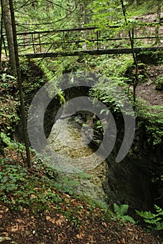 A steel suspension bridge over the river in the Slovak Paradise National Park