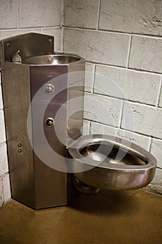 steel toilet bowl and wash basin on stone wall photo