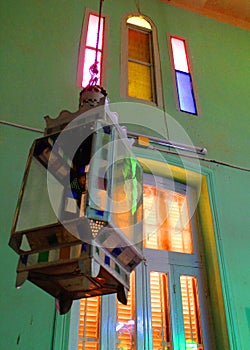 A steel vintage lamp with a colorful window in the mosque of Abou el oyoun in Assuit photo