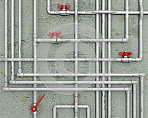 Steel water pipes with red faucets in front of concrete wall,