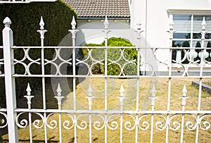 Steel white fence with a house in background