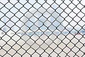 Steel wire mesh as a fence with blurred background of skylines