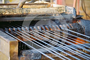 Steel wire metal feeding into bending machine in the industrial factory.
