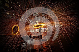 Steel wool photography during the night near a river in Canary Wharf in London