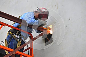 Steel worker welding a joist in place.