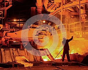 Steelworker near a blast furnace with sparks. Foundry. Heavy industry