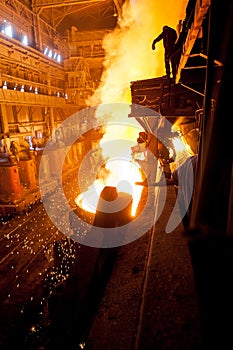 Steelworker near the tanks with hot metal photo