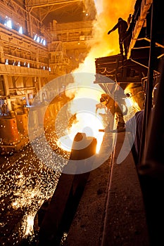 Steelworker near the tanks with hot metal photo