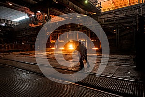 Steelworker near the working open hearth furnace