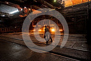 Steelworker near the working open hearth furnace photo