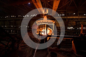 Steelworker at work near the tanks with hot metal