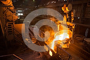 Steelworker at work near the tanks with hot metal photo