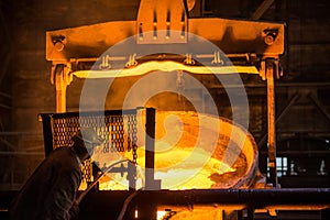 Steelworker at work near the tanks with hot metal