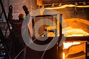 Steelworker at work near the tanks with hot metal