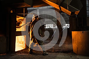 Steelworker at work near the working arc furnace photo