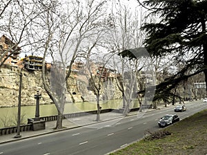 Steep Bank of the Kura river in Tbilisi with buildings at the top of the Bank