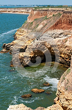 Steep clayey and shell rock shore overgrown with wild steppe vegetation on the island of Berezan, Ukraine